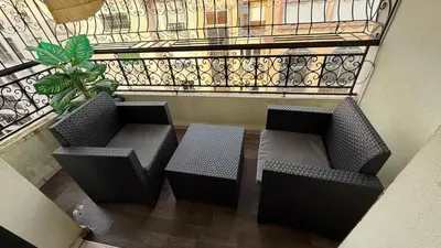 two chairs and a table in front of a balcony at Appartement de haut standing in Fès