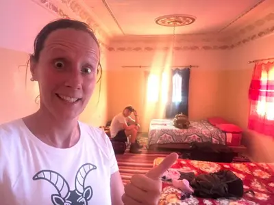 a woman giving a thumbs up in a bedroom at Maison D'hote Chez La Famille in Tamellalt