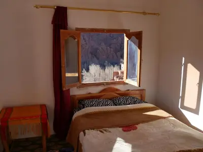 a bedroom with a bed and a window at Maison D'hote Chez La Famille in Tamellalt