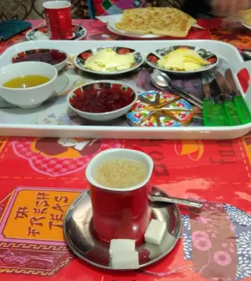 a table with a cup of coffee and a tray of food at Hotel Imilchil in Zaouiat Cheikh