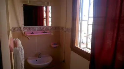 a bathroom with a sink and a window at Hotel Imilchil in Zaouiat Cheikh