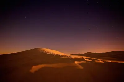 a shadow of a camel in the desert at night at Aladdin Desert Camp - Mhamid Erg Chigaga Escape in El Gouera