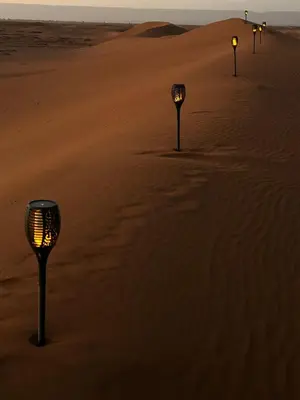 a row of lights in the sand in the desert at Aladdin Desert Camp - Mhamid Erg Chigaga Escape in El Gouera