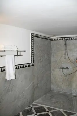 a bathroom with a shower with a shower curtain at Riad Batchisarai in Fès