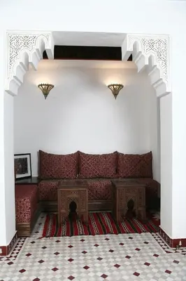 a living room with a red couch and a table at Riad Batchisarai in Fès