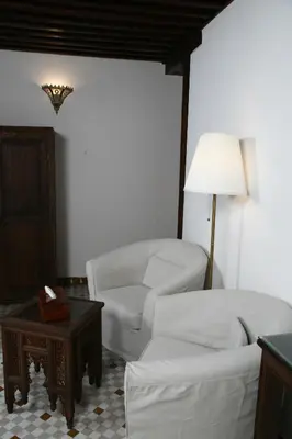 a living room with two white couches and a table at Riad Batchisarai in Fès