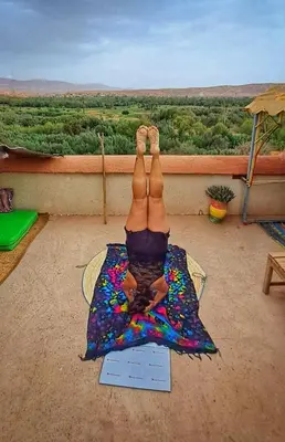a person doing a yoga pose on a mat with their legs in the air at Hike and Chill Homestay in Tinerhir