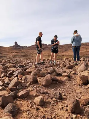 a group of three people standing on a pile of rocks at Hike and Chill Homestay in Tinerhir