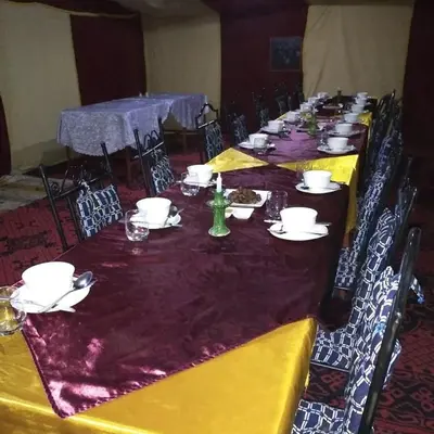 a long table with plates and dishes on it at berber sahara in Zagora