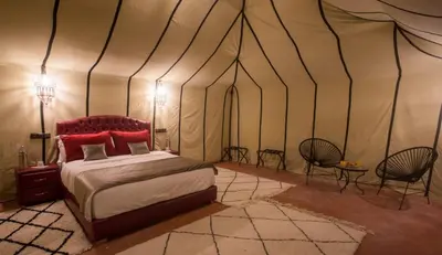 a bedroom with a bed in a tent at Luxury Desert Camp Amanar in Merzouga