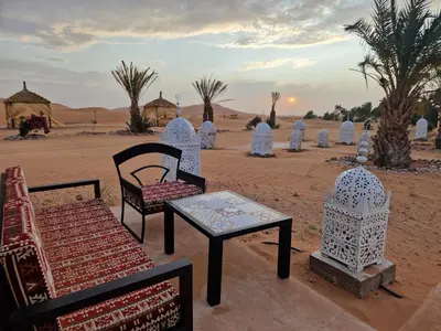 a group of chairs and a table in the desert at Luxury Desert Camp Amanar in Merzouga