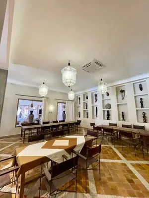 a large room with tables and chairs and chandeliers at Bab Rimal - Desert Hotel in M'hamid El Ghizlane in Mhamid