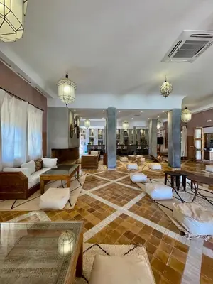 a lobby with couches and tables in a building at Bab Rimal - Desert Hotel in M'hamid El Ghizlane in Mhamid
