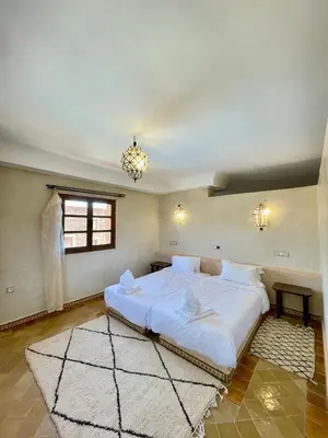 a bedroom with a large white bed in it at Bab Rimal - Desert Hotel in M'hamid El Ghizlane in Mhamid