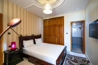 a bedroom with a bed and a lamp and a television at Appartement Luxe Simo in Fès