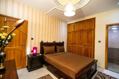 a bedroom with a bed and a table and a lamp at Appartement Luxe Simo in Fès