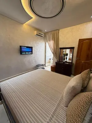 a bedroom with a large bed with a tv on the ceiling at Appartement Luxe Simo in Fès