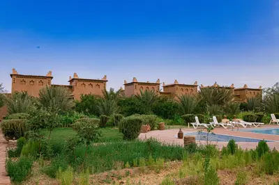 a resort with a swimming pool in front of a building at Maison D'hôte Amridil in Skoura