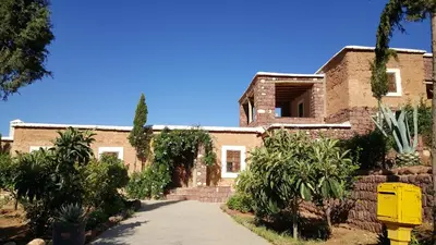 an old brick building with a sidewalk in front of it at Le Douar Berbere in Ourika
