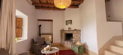 a living room with a fireplace and a chair at Le Douar Berbere in Ourika