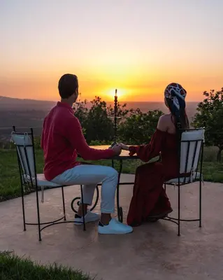 a man and woman sitting at a table watching the sunset at Le Douar Berbere in Ourika