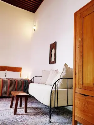 a bedroom with a bed and a table in it at Riad Inspira in Meknès