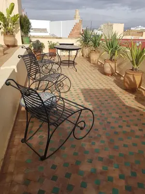 a row of chairs and tables on a balcony at Riad Inspira in Meknès