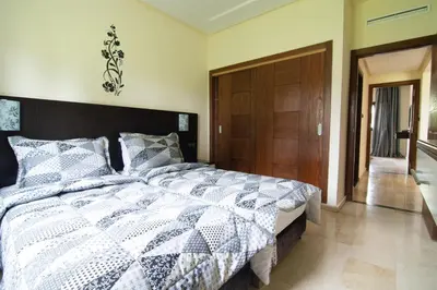 a bedroom with a large bed and a wooden door at Résidence Hôtelière Le Diamant Vert in Fès
