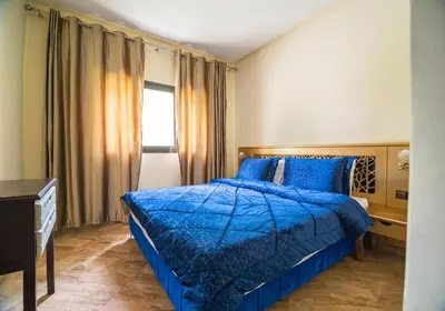 a bedroom with a blue bed and a window at Résidence Hôtelière Le Diamant Vert in Fès