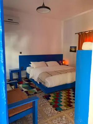 a bedroom with a blue bed in a room at Chez Youssef in Merzouga