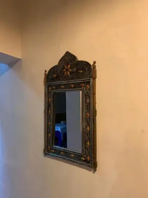 an ornate mirror on a wall in a room at Chez Youssef in Merzouga