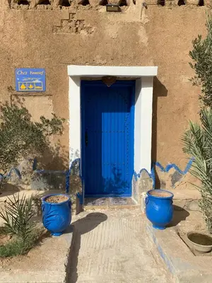 two blue pots in front of a blue door at Chez Youssef in Merzouga