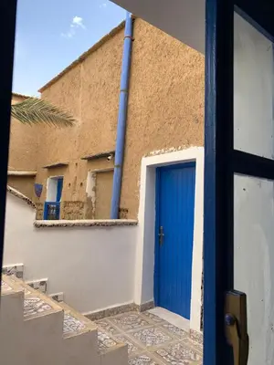 a blue door on the side of a building at Chez Youssef in Merzouga