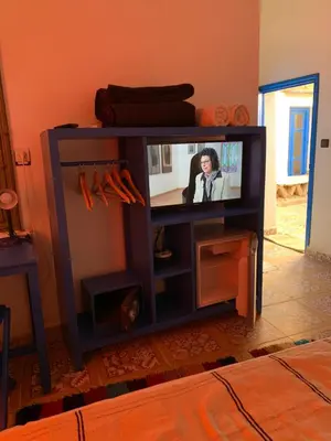 a television in a stand with a tv screen at Chez Youssef in Merzouga