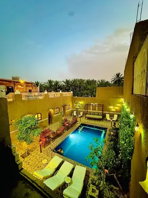 a swimming pool with lounge chairs and a resort at La Petite Kasbah in Zagora