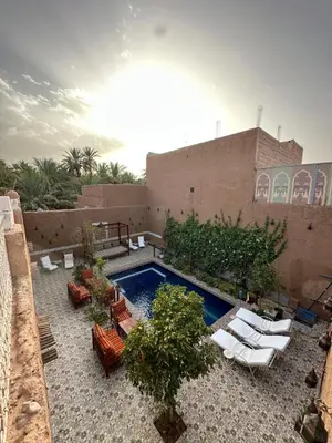 a patio with chairs and a swimming pool on a building at La Petite Kasbah in Zagora