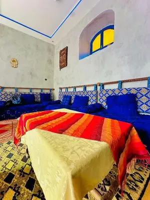 a bedroom with a bed with a colorful blanket at La Petite Kasbah in Zagora