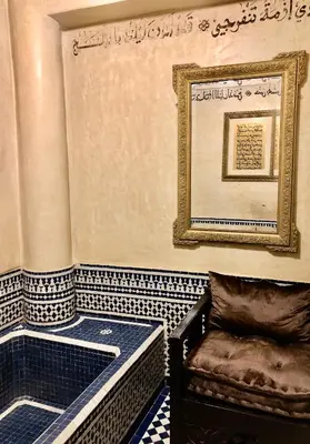 a room with a tub with a chair and a picture at Riad Ibn Battouta & Spa in Fès