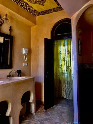 a bathroom with a sink and a door in a room at Riad Ibn Battouta & Spa in Fès