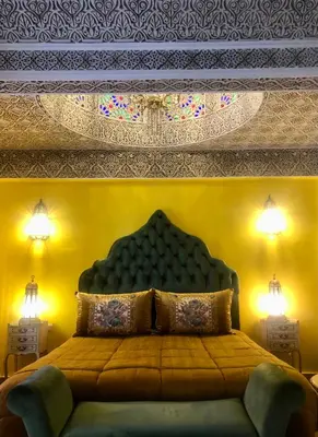 a bedroom with a bed with a large head board at Riad Ibn Battouta & Spa in Fès
