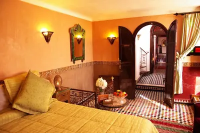 a bedroom with a bed and an arched doorway at Riad Ibn Battouta & Spa in Fès