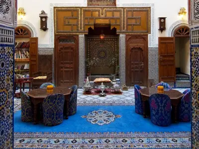 a room with tables and chairs in a building at Riad Ibn Khaldoun in Fès