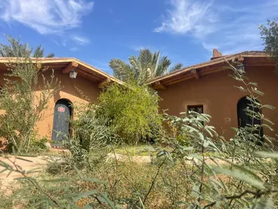 a house in the middle of a field at Dar Azawad Boutique Hotel - Mhamid Sahara Stay in Mhamid
