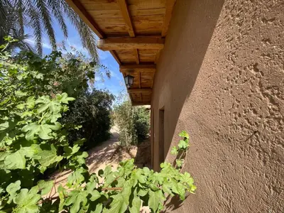 a porch of a house with a wooden roof at Dar Azawad Boutique Hotel - Mhamid Sahara Stay in Mhamid