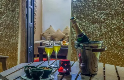 a bottle of champagne and two glasses on a table at Dar Azawad Boutique Hotel - Mhamid Sahara Stay in Mhamid