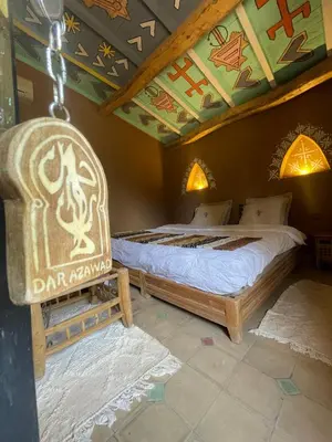 a bedroom with two beds in a room with a ceiling at Dar Azawad Boutique Hotel - Mhamid Sahara Stay in Mhamid