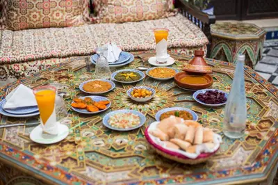 a table with plates of food and drinks on it at Riad Ghita in Fès