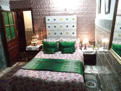 a bedroom with a bed with green pillows at Dar Nouzha A in Fès