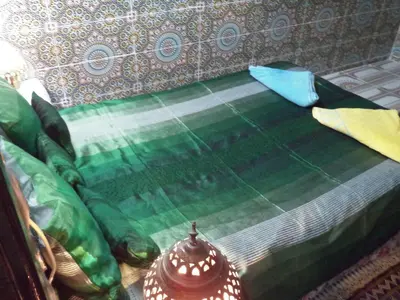 a close up of a bed with green sheets and pillows at Dar Nouzha A in Fès