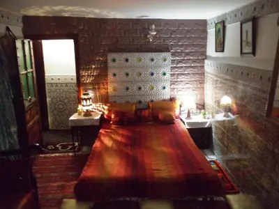 a bedroom with a bed and two sinks and a mirror at Dar Nouzha A in Fès